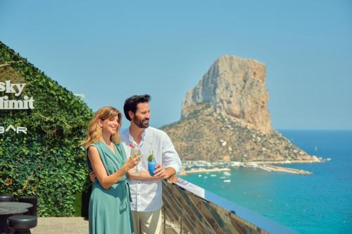 a man and a woman standing next to the ocean at ESTIMAR Calpe Suitopia in Calpe