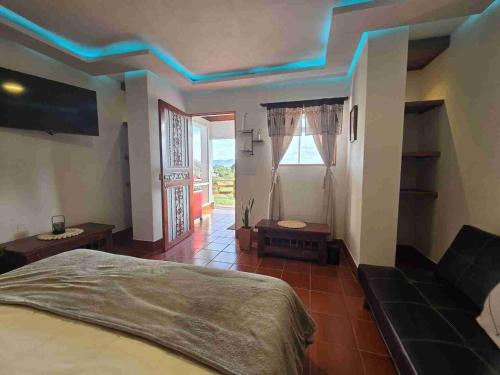 a bedroom with a bed with blue lights on the ceiling at Luxurious country cabin, BBQ, Jacuzzi, TV, WiFi in Marinilla
