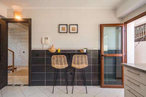 丹吉尔Tanger Marina - 2 Floor Luxury Penthouse with Terrace - Fantastic Location的厨房配有黑白瓷砖和凳子