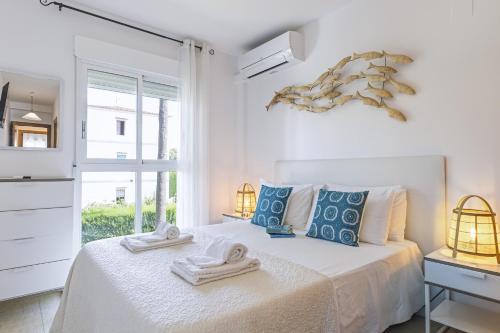 a white bedroom with a bed with towels on it at El Velero in El Tosalet