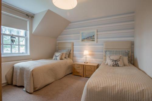 1 dormitorio con 2 camas y ventana en Sea View Lodge, en Nairn