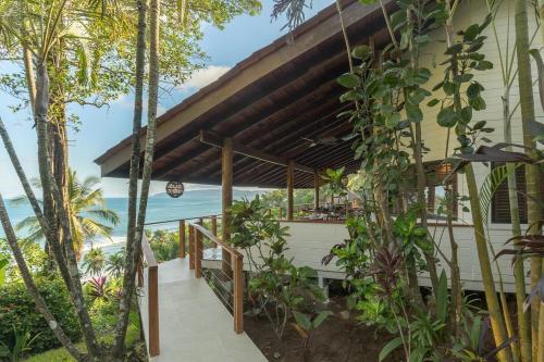 a porch of a house with a view of the ocean at Tropical cliff house, 3 minute walk to the beach in Tambor