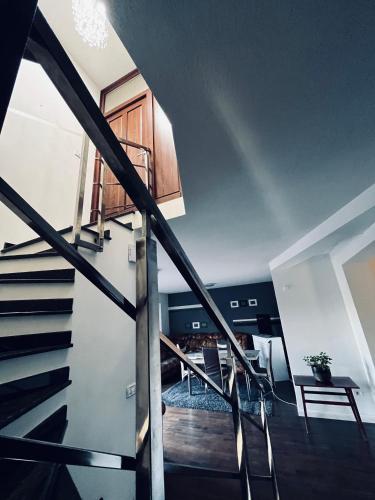 a staircase leading up to a living room with a table and chairs at AgroVila ABEL in Şoimoş