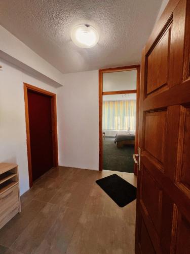 an empty room with a door and a living room at Apartman Alinac in Cazin