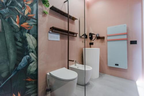 a bathroom with a toilet and a sink at Tropicalia Suites by Wonderful Italy in Aci Castello
