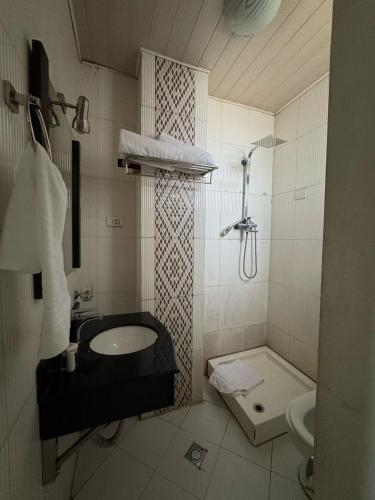 un bagno con lavandino, WC e doccia di Beta Guesthouse ad Addis Abeba