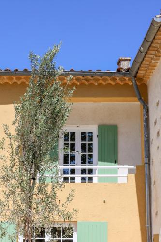 a house with a green window and a tree at Domaine Robert in Rognes