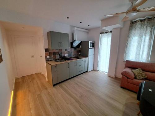 a living room with a kitchen and a couch at Piso Jaén Parque in Jaén
