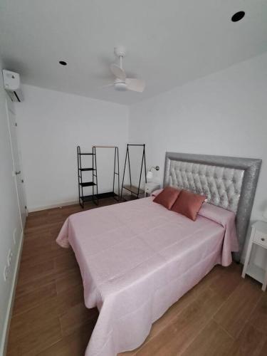 ein Schlafzimmer mit einem großen Bett und einer rosa Decke in der Unterkunft Piso Jaén Parque in Jaén