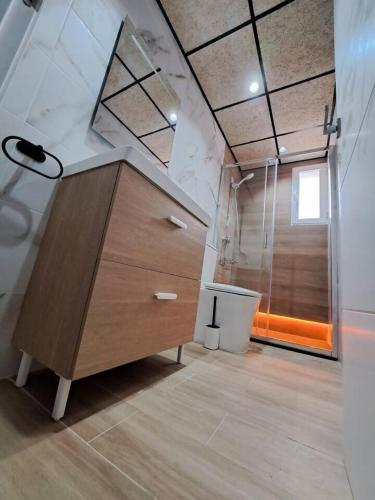 ein Badezimmer mit einer Holzkommode und einer Dusche in der Unterkunft Piso Jaén Parque in Jaén