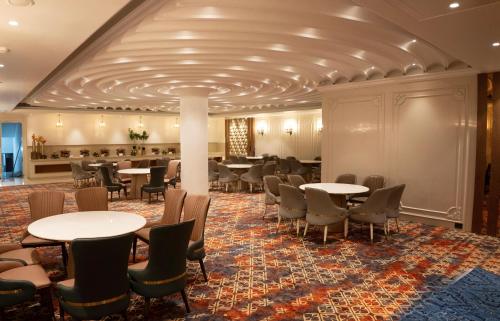 une salle à manger avec tables et chaises dans un bâtiment dans l'établissement Maribella Hotel & Resort By iO Hotels, à Mānānwāla