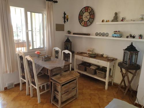 a dining room with a table and a clock on the wall at Coastal Villa Near Beaches in Moraira