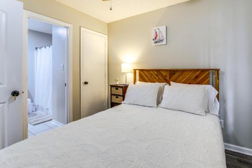 a bedroom with a white bed with a wooden headboard at Jacksonville Home By Camp Lejeune, Beaches and More! in Jacksonville