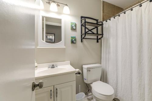 a white bathroom with a toilet and a sink at Jacksonville Home By Camp Lejeune, Beaches and More! in Jacksonville