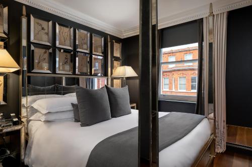 a bedroom with a bed with black walls and a window at The Franklin London - Starhotels Collezione in London