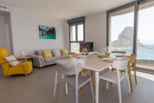 a dining room with a table and chairs and a couch at Apartamento Infinium 4 - Costa CarpeDiem in Calpe