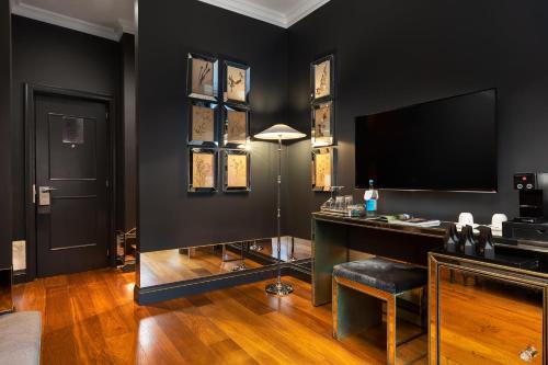 a black room with a desk and a television at The Franklin London - Starhotels Collezione in London