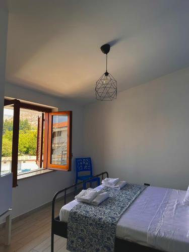 a bedroom with a bed and a pendant light at bruni rooms in Cirella