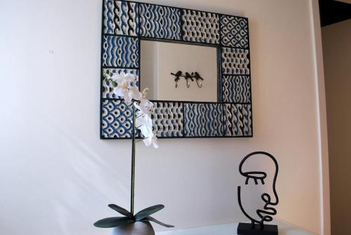 a mirror on a wall above a table with a plant at Refúgio da Luz in Lisbon