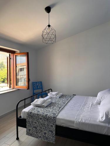 a bedroom with a bed and a pendant light at bruni rooms in Cirella