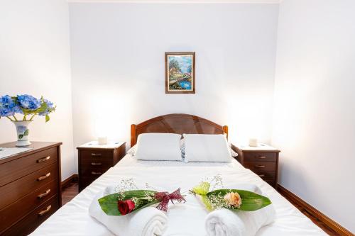 a bedroom with a bed with towels on it at Apartamento Hortênsia in Furnas
