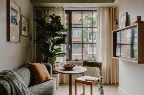 a living room with a couch and a table and a window at Mason & Fifth, Westbourne Park in London