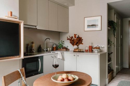 a kitchen with a table with a bowl of fruit on it at Mason & Fifth, Westbourne Park in London