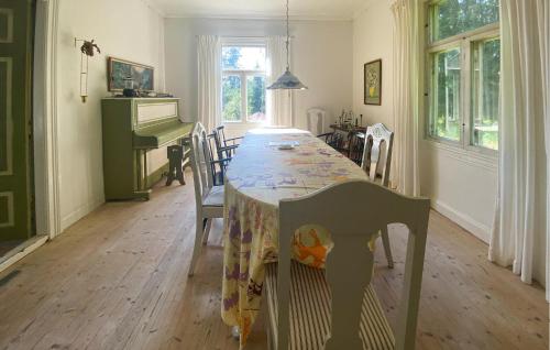 a dining room with a table with chairs and a piano at Stunning Home In Skillingaryd With Sauna in Ryd