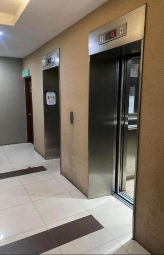 an empty hallway with a stainless steel refrigerator in a building at Crystal Studio Apartment KBCP in Kota Bharu