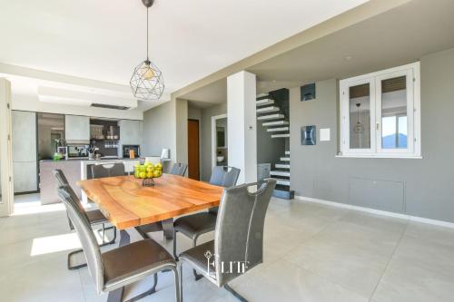 a dining room with a wooden table and chairs at Lake Maggiore View Apt Meina in Meina