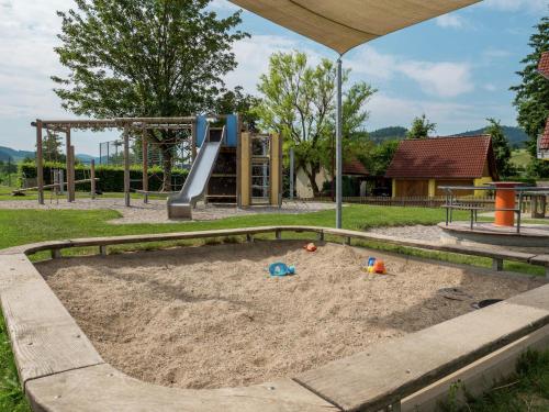 a sandpit in a playground with a slide at Gemütliche Ferienwohnung im Schwarzwald in Fohren