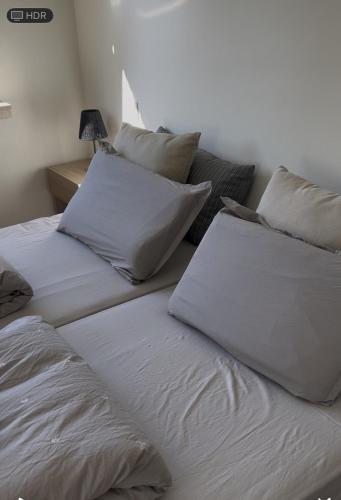 two beds with white sheets and pillows in a room at Maison François in Oostkamp