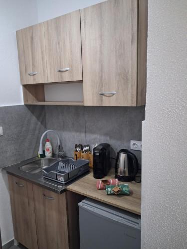 a kitchen with wooden cabinets and a counter top at SunWaves Apartments in Keramotí