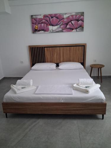 a large bed with two towels on top of it at SunWaves Apartments in Keramotí
