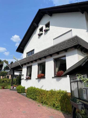 a white house with flower boxes on the windows at Waldhof Hochsauerland in Medebach
