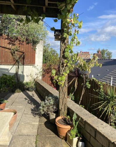 a garden with potted plants and a stone wall at The Mews Llantrisant in Llantrisant