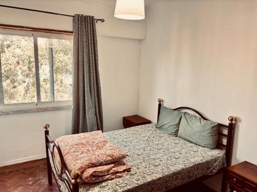 a bedroom with a bed and a window at Solace Apartment in Odivelas