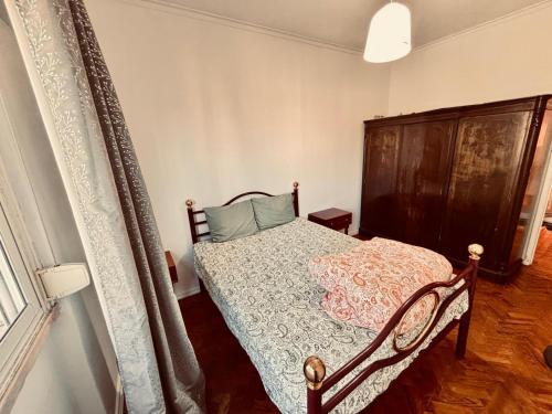 a bedroom with a bed with a wooden headboard at Solace Apartment in Odivelas