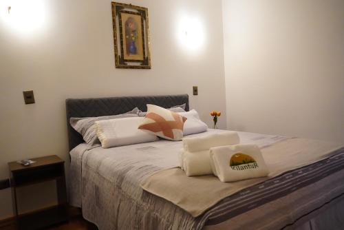 a bedroom with a bed with pillows on it at Kilantur Plaza in Iquique