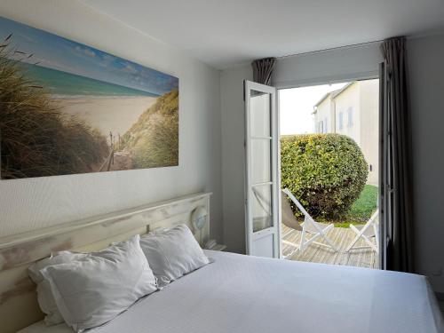 a bedroom with a bed and a view of a beach at Thalacap Île de Ré - Thalasso & Spa in Ars-en-Ré
