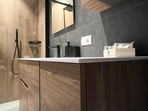 ein Badezimmer mit Waschbecken und Spiegel in der Unterkunft Mountain Garden Apartments Larice in Giustino