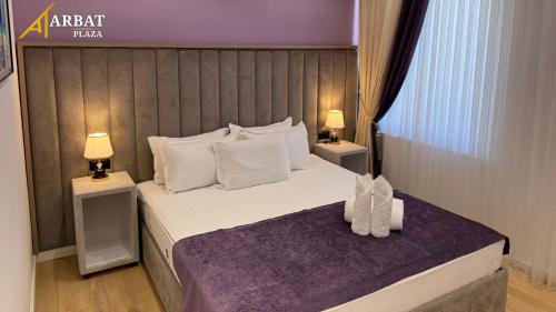 a bedroom with a large bed with two night stands at ARBAT Plaza in Qarshi