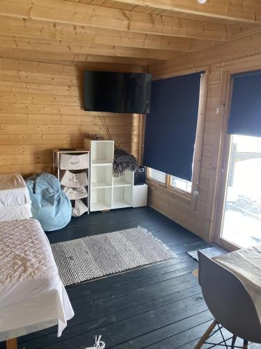 a bedroom with a bed and a flat screen tv at Lapland cabin in Kilpisjärvi