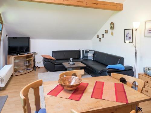 a living room with a table and a couch at Ferienwohnung in Gütenbach in Furtwangen