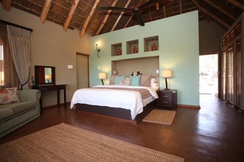 um quarto com uma cama grande e um sofá em Matingwe Lodge em Vaalwater