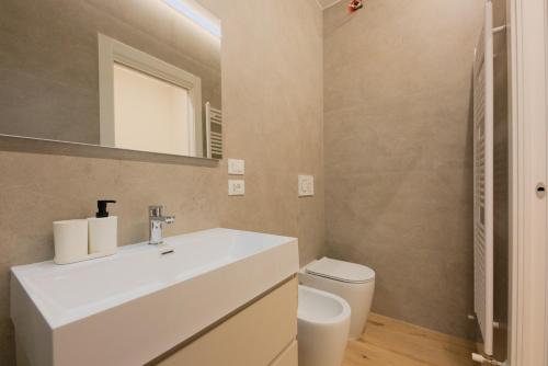 a bathroom with a white sink and a toilet at Alpine Escape 1BR Apartment A in Tarvisio