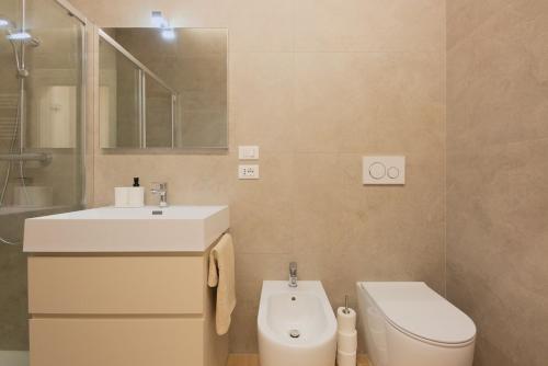a bathroom with a sink and a toilet and a mirror at Alpine Escape 1BR Apartment A in Tarvisio