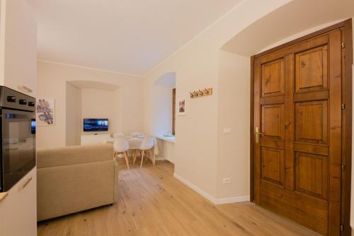 a living room with a large wooden door and a table at Alpine Escape 1BR Apartment A in Tarvisio