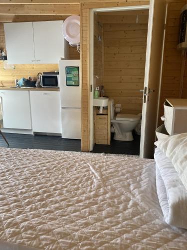 a bedroom with a bed and a kitchen with a refrigerator at Lapland cabin in Kilpisjärvi