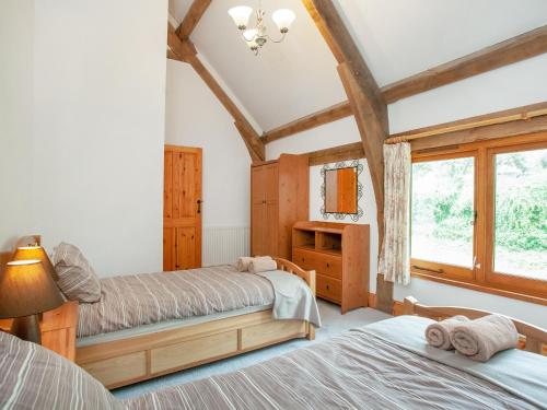 a bedroom with two beds and a window at Pondmead in Monk Okehampton